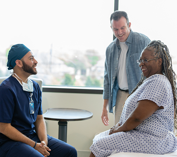 Smiling patient with doctor and family member.  Positive healthcare setting.